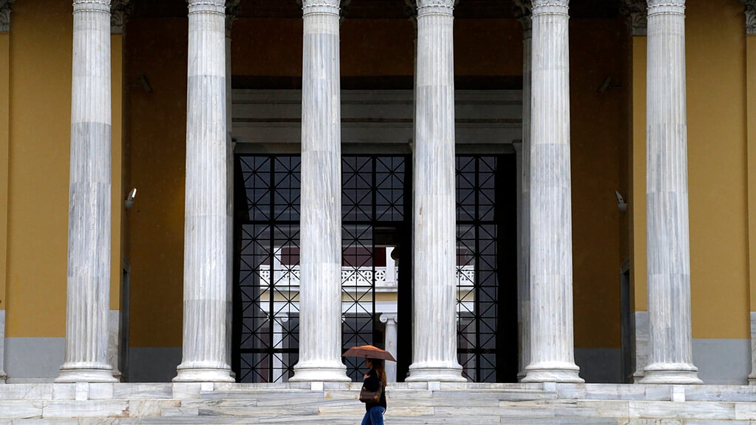 Περαστική με ομπρέλα έξω από το Ζάππειο Μέγαρο στην Αθήνα - φώτο αρχείου