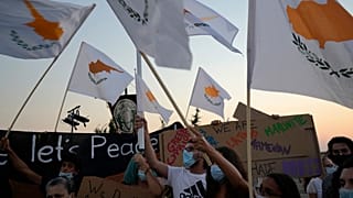 People hold Cyprus flags during a protest against the 47th anniversary of the Turkish invasion on the island, in Dherynia, Cyprus, July 2021
