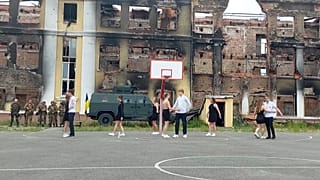 A megmaradt végzős diákok tánca az iskola romjai mellett