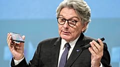 EU-Kommissar Thierry Breton mit Handy und Ladegerät