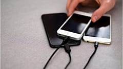 Phones are shown charging. The EU initiative would create a common charger.