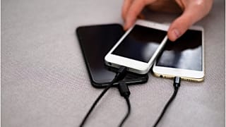 Phones are shown charging. The EU initiative would create a common charger.