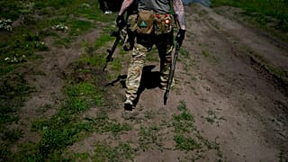 Un miliciano civil sostiene una escopeta y un rifle durante un entrenamiento en un campo de tiro en las afueras de Kiev, Ucrania, el martes 7 de junio de 2022