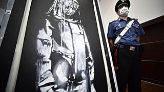 The Banksy mural beside a French official