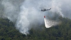 Un hélicoptère de lutte contre les incendies largue de l'eau sur le feu de forêt de Batramaz au Liban, le 8 juin 2022.