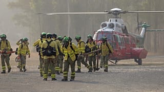 Un equipo de bomberos camina por la zona de un incendio forestal en Pujerra, Málaga, el jueves 9 de junio de 2022.