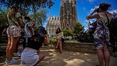 Personas toman fotos frente a la Basílica de la Sagrada Familia en Barcelona, España.