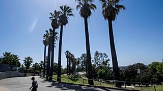 Un hombre camina bajo el calor de la tarde en el parque Hillcrest en Fullerton, California, el jueves 7 de abril de 2022