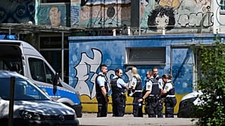 Police officers secure a crime scene in front of a school in Esslingen.