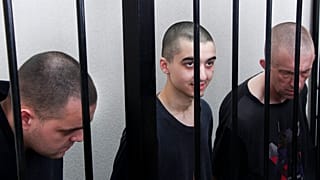 Δύο Βρετανοί και ένας Μαροκινός αιχμάλωτος πολέμου πίσω από τα κάγκελα κατά τη διάρκεια της δίκης από τις φιλορωσικές αρχές του Ντόνετσκ