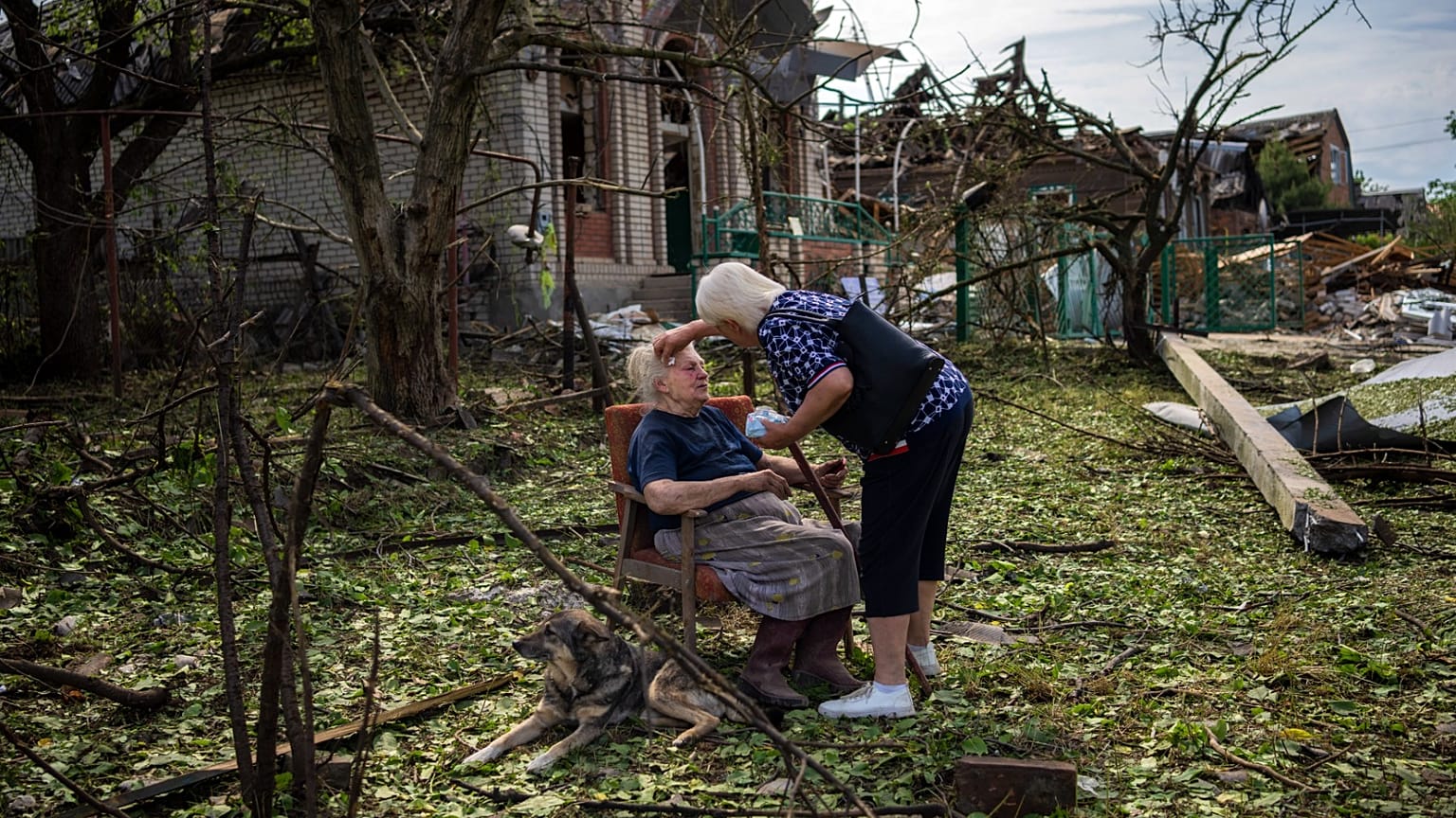 Elena Holovko sits among debris outside her house damaged after a missile strike in Druzhkivka, eastern Ukraine, 5 June 2022