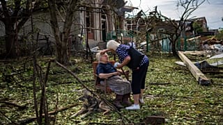 Elena Holovko sits among debris outside her house damaged after a missile strike in Druzhkivka, eastern Ukraine, 5 June 2022