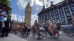 Cyclists driving past Big Ben.