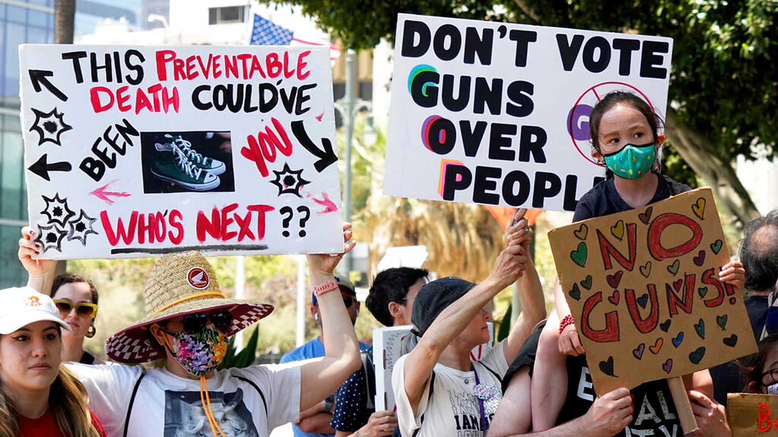 Protesters hold up signs during a gun control rally outside City Hall in Los Angeles 