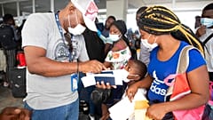 Haitianos esperan para subirse a un vuelo chárter en dirección a Chile en el aeropuerto de Puerto Príncipe, Haití