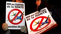 Protestors, holding posters which read, "No to the charter flights of shame"