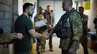 June 6, 2022, Ukrainian president Volodymyr Zelenskyy shakes hands with a Ukrainian serviceman during a visit to the frontline. 