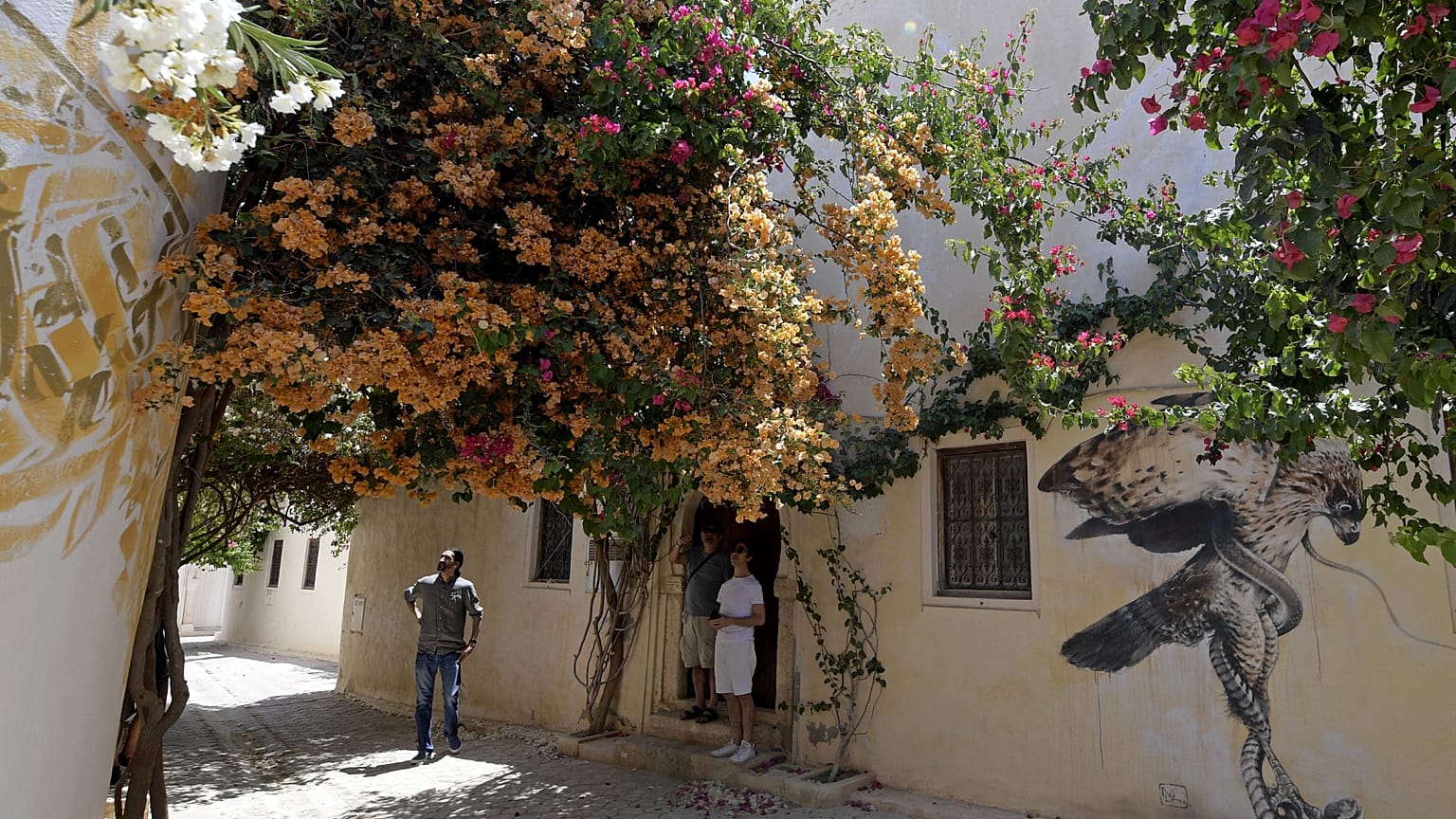 أشخاص يسيرون في بلدة الرياض (الحارة الصغيرة) في منتجع جزيرة جربة التونسية. 2022/05/19