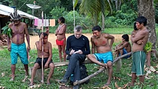 November 15, 2019 veteran foreign correspondent Dom Phillips (C) takes notes as he talks with indigenous people at the Aldeia Maloca Papiu, Roraima State, Brazil.