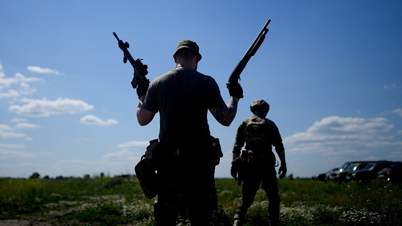 A civilian militia man holds a shotgun and a rifle during training at a shooting range in outskirts Kyiv, Ukraine, Tuesday, June 7, 2022