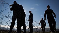 Slovenian soldiers erect a razor-wired fence on the Croatian border in Gibina, Slovenia, Wednesday, Nov. 11, 2015