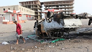 صورة أرشيفية لمسلح بجانب سيارة تم تفجيرها في عدن، اليمن 24/3/2022