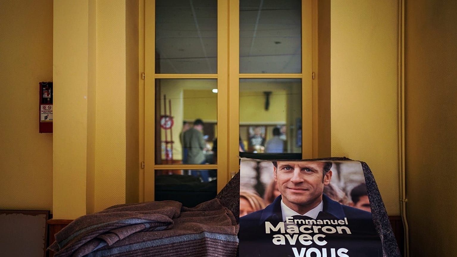 A campaign poster reading "Emmanuel Macron with you" is displayed during a local meeting for the upcoming parliamentary elections, in Lyon, central France, June 7, 2022.
