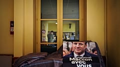 A campaign poster reading "Emmanuel Macron with you" is displayed during a local meeting for the upcoming parliamentary elections, in Lyon, central France, June 7, 2022.