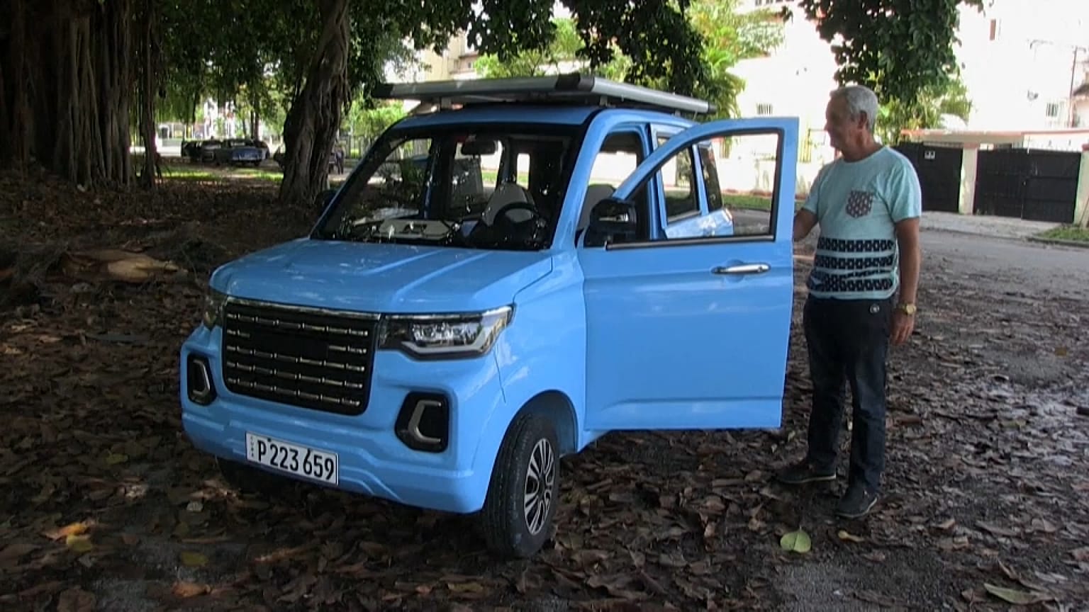 El taxista retirado, Sixto González, al lado de su cuatriciclo eléctrico azul.