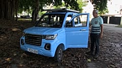 El taxista retirado, Sixto González, al lado de su cuatriciclo eléctrico azul.