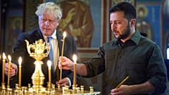 Selenskyj und Johnson entzünden während eines Kirchenbesuchs Kerzen