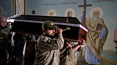 Soldiers carry the coffin of activist and soldier Roman Ratushnyi for his memorial service in Kyiv, 18 June 2022