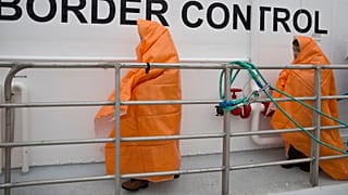 Two children prepare to disembark with other 53 migrants and refugees after they were rescued near the shores of Lesbos in March 2016