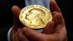 FILE — Bidder Ole Bjorn Fausa, of Norway, holds the 1936 Nobel Peace Prize medal in Baltimore, March 27, 2014, the second Nobel Peace Prize ever to come to auction.