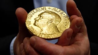 FILE — Bidder Ole Bjorn Fausa, of Norway, holds the 1936 Nobel Peace Prize medal in Baltimore, March 27, 2014, the second Nobel Peace Prize ever to come to auction.