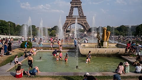 People enjoy the sun and the fountains of the Trocadero gardens in Paris.