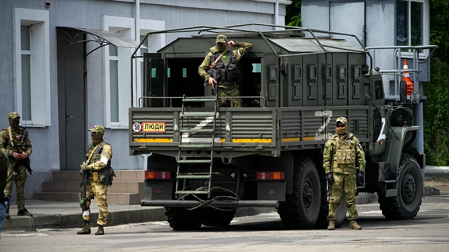 Russian soldiers guard an area as a group of foreign journalists visit in Kherson, Kherson region, south Ukraine, Friday, May 20, 2022