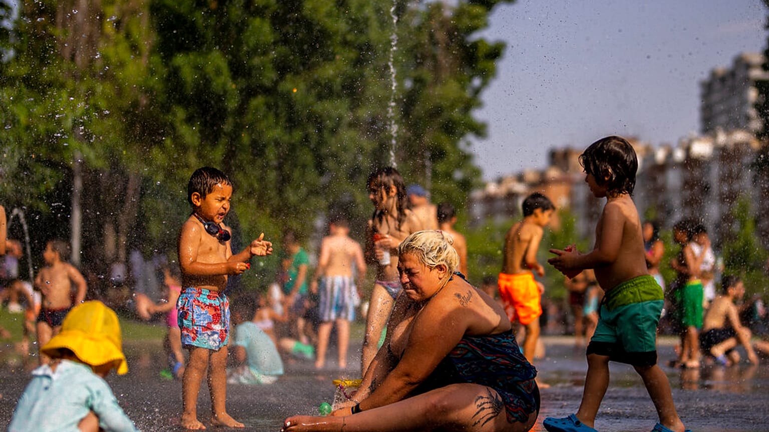 Niños y adultos se refrescan en una fuente en un parque junto al río en Madrid, España, el viernes 17 de junio de 2022.