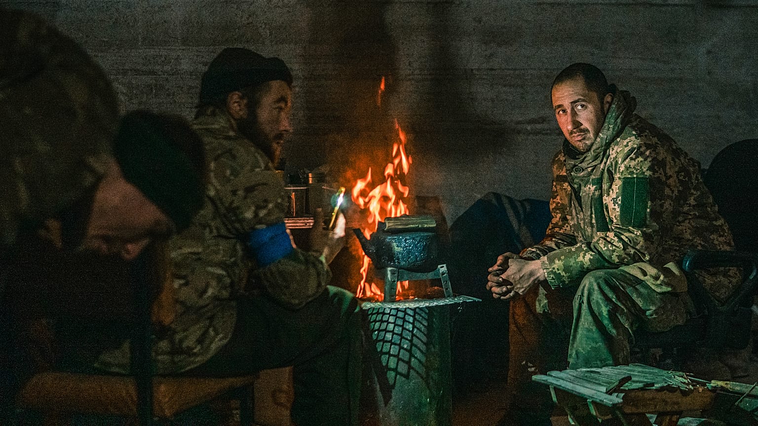 The Mariupol defenders sit near the fire at the Azovstal steel plant during its siege by Russian army. May 2022