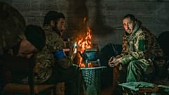 Los defensores de Mariupol se sientan cerca del fuego en la planta siderúrgica de Azovstal durante su asedio por el ejército ruso. Mayo de 2022 