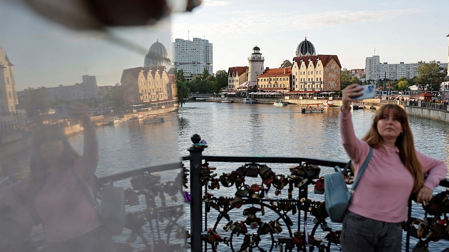 A woman takes a selfie on an embankment of the Pregolya River in Kaliningrad