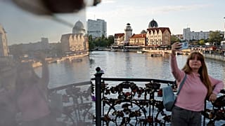A woman takes a selfie on an embankment of the Pregolya River in Kaliningrad