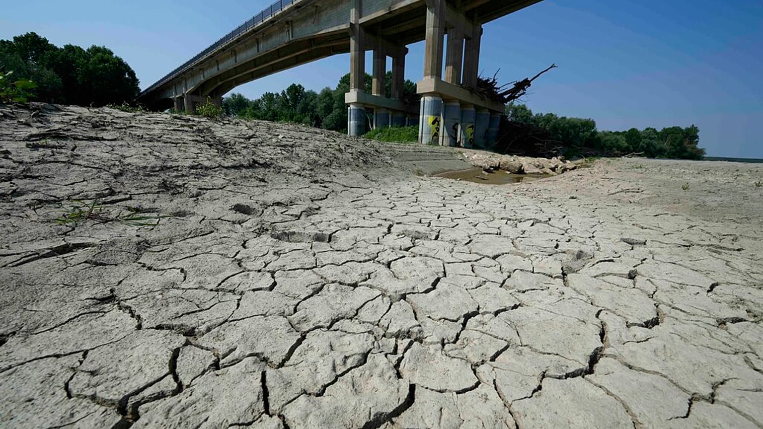 Trockenes, rissiges Land unter einer Brücke im italienischen Boretto, wo normalerweise der Po entlangfließt.