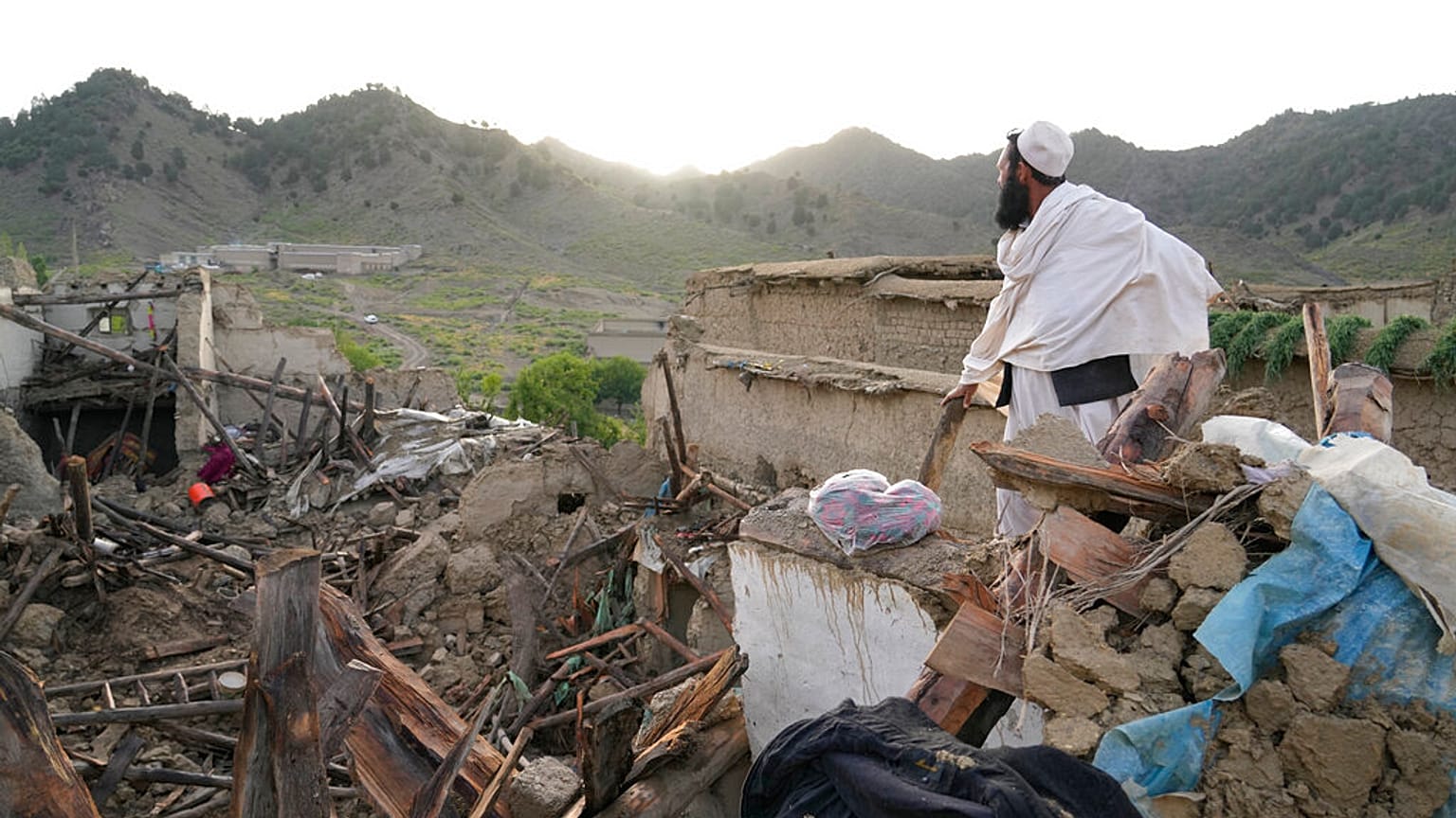 A man stands among destruction after an earthquake in Gayan village