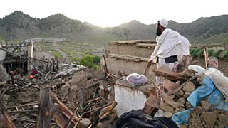 A man stands among destruction after an earthquake in Gayan village