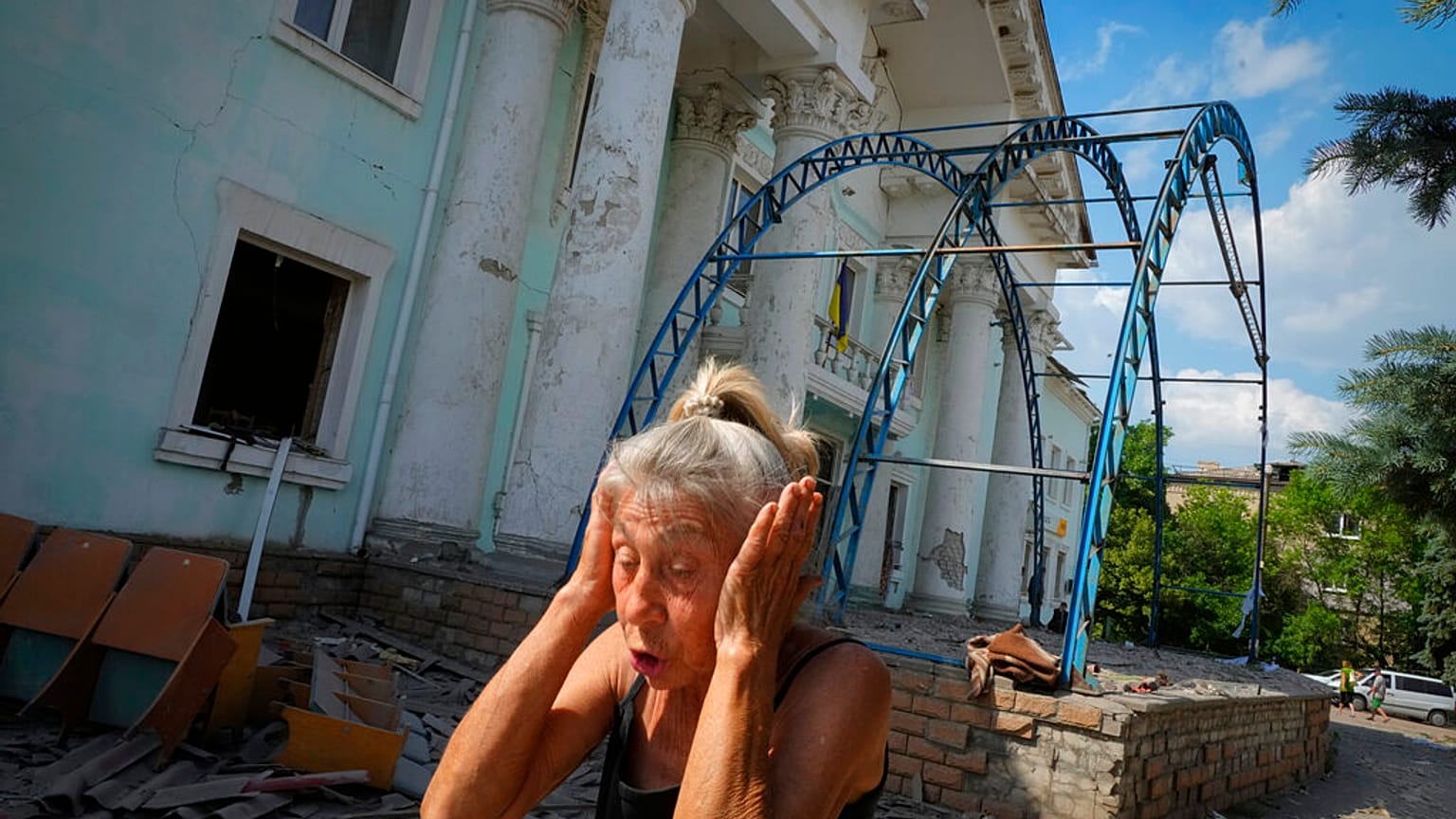Mulher tapa os ouvidos para não ouvir bombardeamentos russos, em Lysychansk, no Donbass, Ucrânia