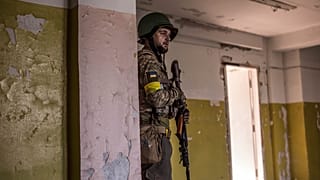 A Ukrainian soldier takes cover during heavy fighting at the front line in Sievierodonetsk, Luhansk region, Ukraine, Wednesday, June 8, 2022.