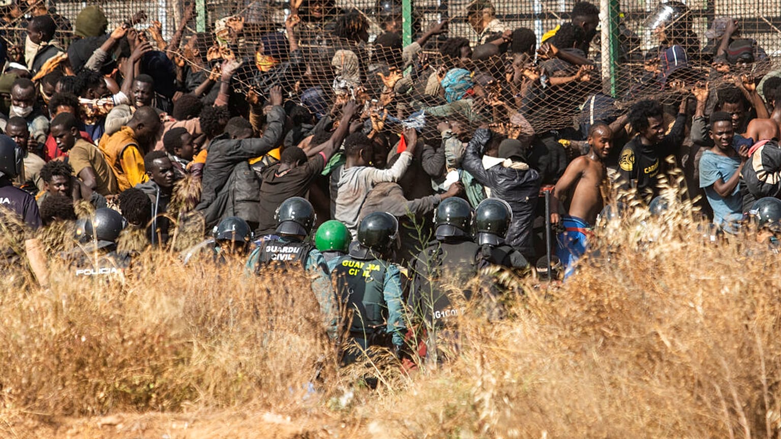 Migrants arrive on Spanish ground after crossing the fences separating the Spanish enclave of Melilla from Morocco in Melilla