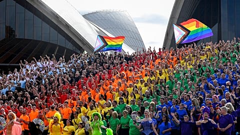 People make a human Progress Pride flag outside the Sydney Opera House