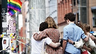 Young people mourn at a crime scene in central Oslo, Norway, on June 25, 2022, in the aftermath of a shooting outside pubs and nightclubs.